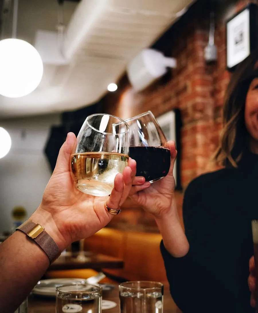 Two glasses of white wine raised in a toast